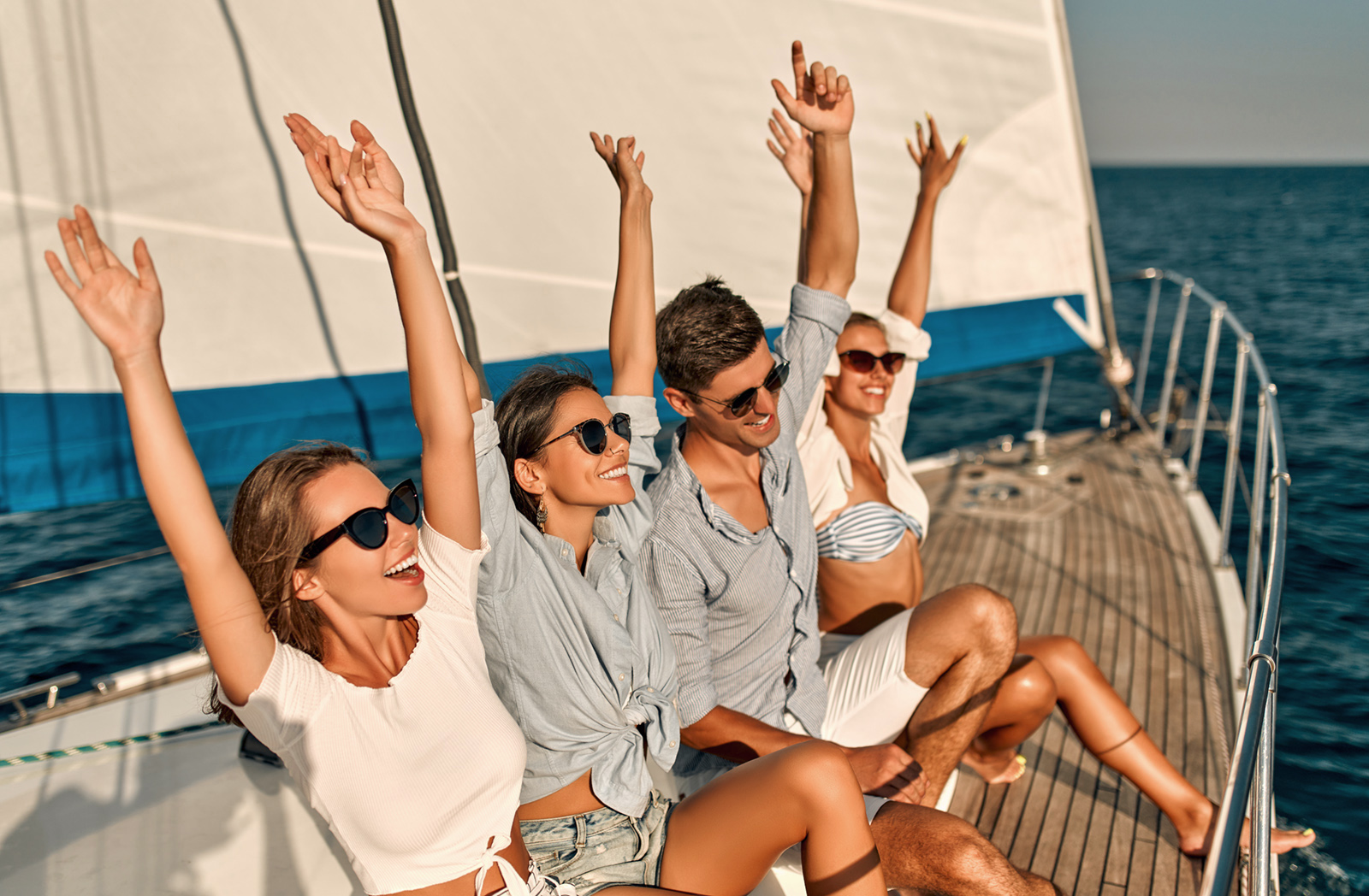 Group of friends relaxing on luxury yacht. Having fun together while sailing in the sea. Traveling and yachting concept.